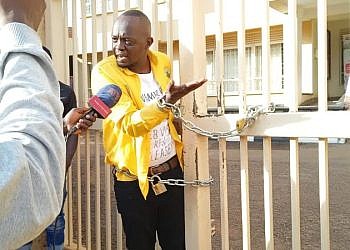 Man chains himself at UNEB gate demanding his academic documents