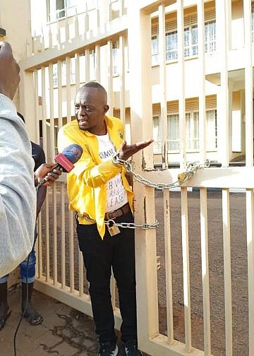 Man chains himself at UNEB gate demanding his academic documents